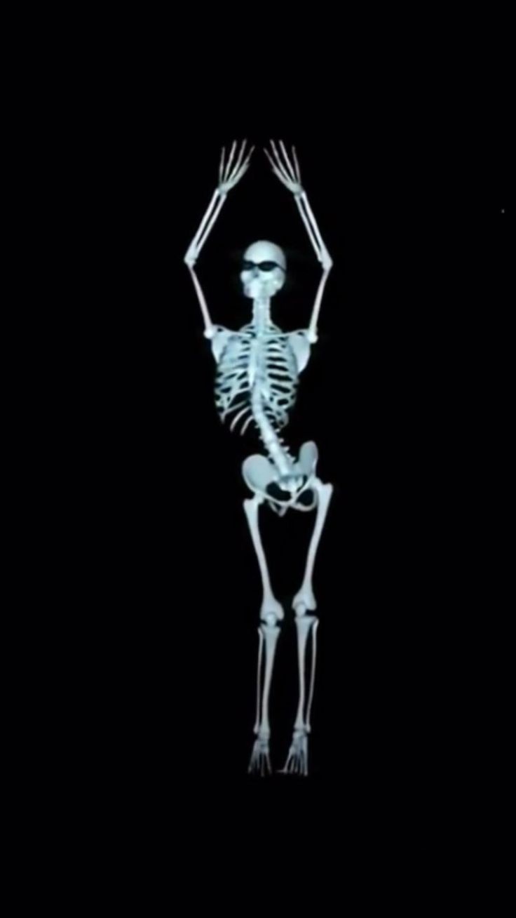 a skeleton is standing in the dark with its arms outstretched and hands extended up to his chest