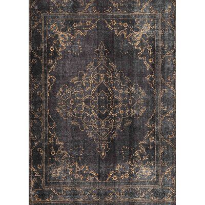 an antique style rug with dark blue and gold colors on the bottom, in front of a white background