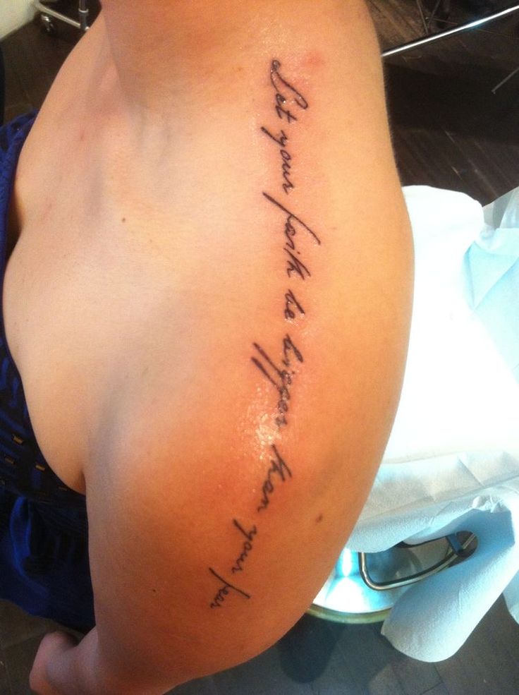 the back of a woman's left shoulder with writing on her right arm and chest