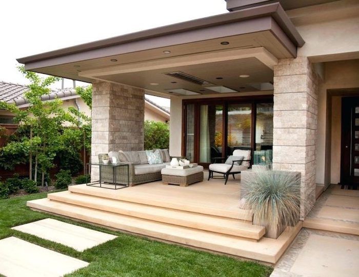 an outdoor living area with steps leading up to the front door