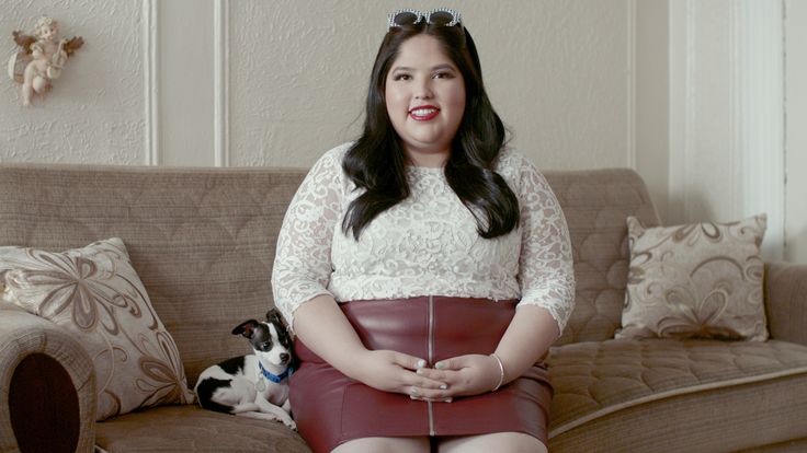 a woman sitting on top of a couch next to a dog