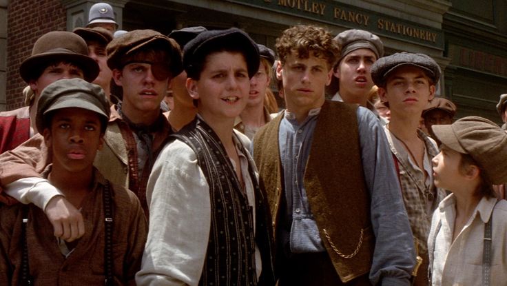 a group of young men standing next to each other in front of a brick building