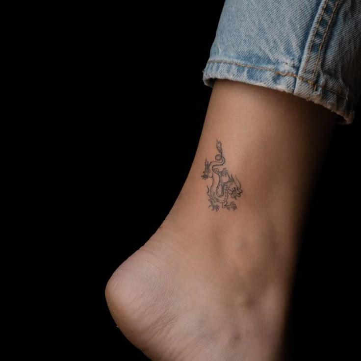 a woman's foot with a small tattoo on it