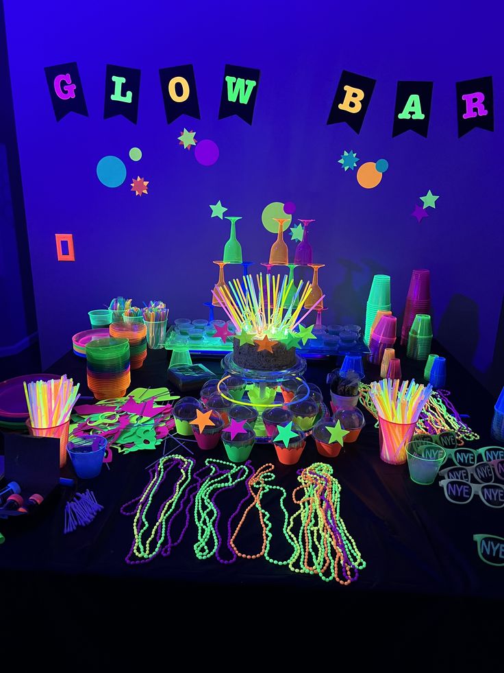 neon glow party supplies and decorations on a table