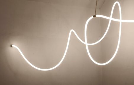 a white neon sign hanging from the side of a wall