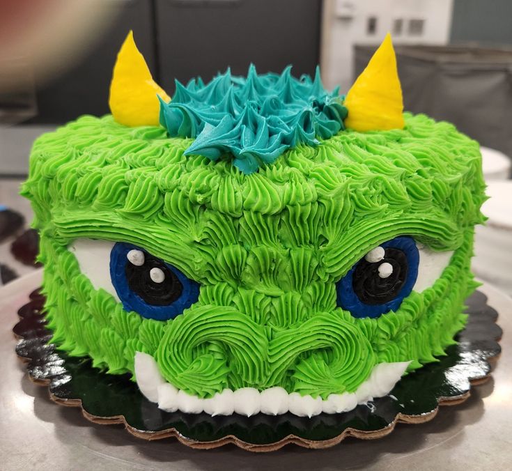 a green cake with blue icing and yellow horns