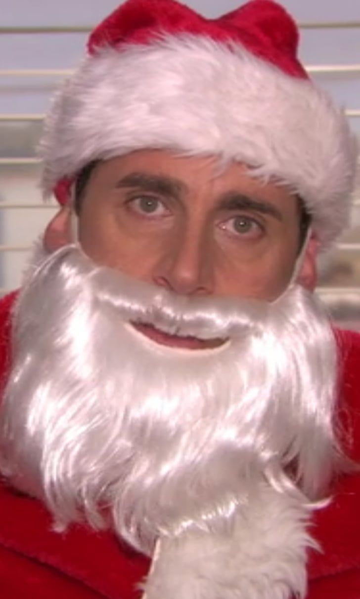 a man in a santa suit with a beard and wearing a santa claus hat is looking at the camera