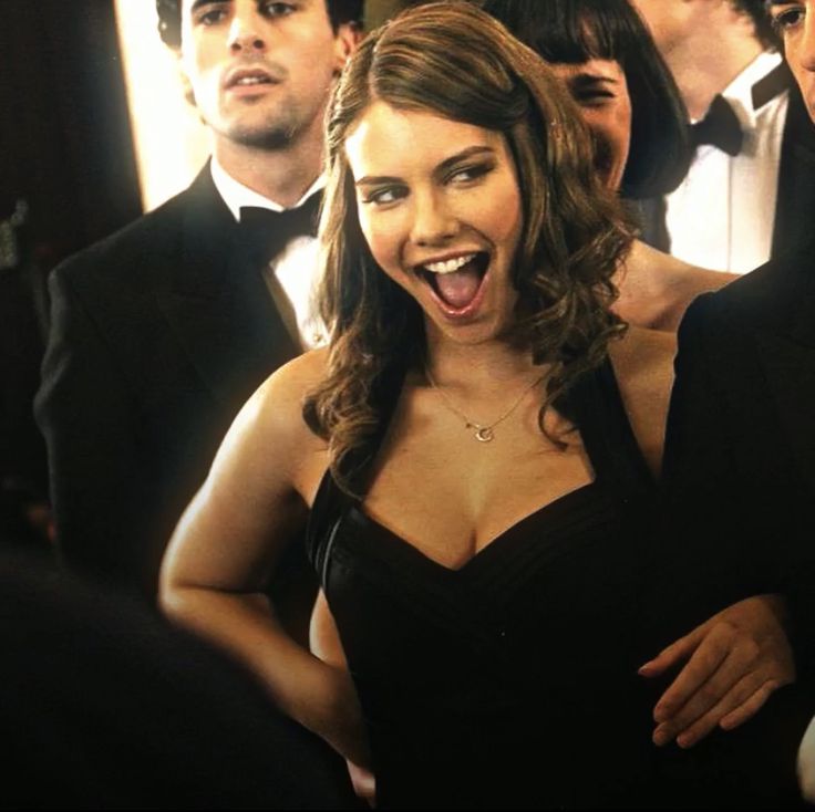 a group of people in tuxedos standing around each other with their mouths open