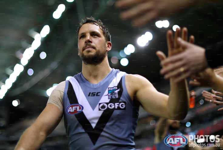 a male afl player with his hands in the air