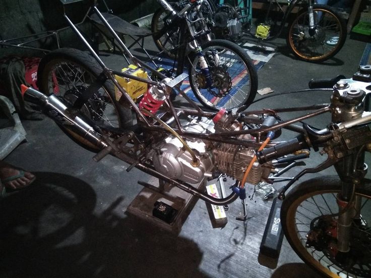 a motorcycle is being worked on in a garage with other bikes and tools around it