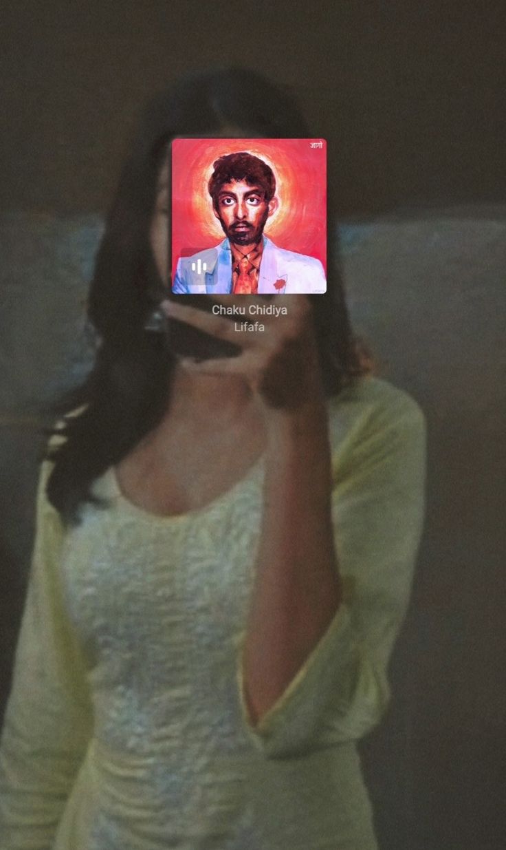 a woman holding up a cell phone to her face with the image of jesus on it