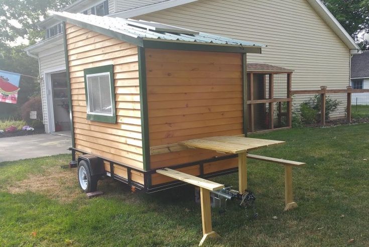 a tiny house sitting on top of a lush green field