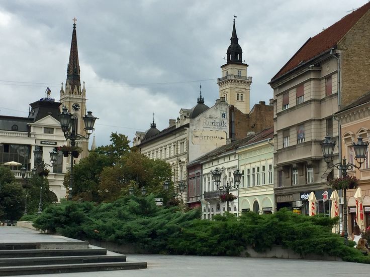 there are many buildings in the city with steeples on each side and a clock tower at the top