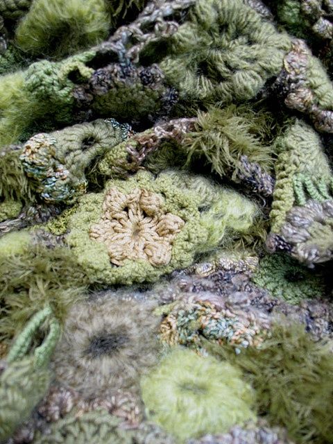 a pile of green and brown stuff on top of a bed covered in mossy material