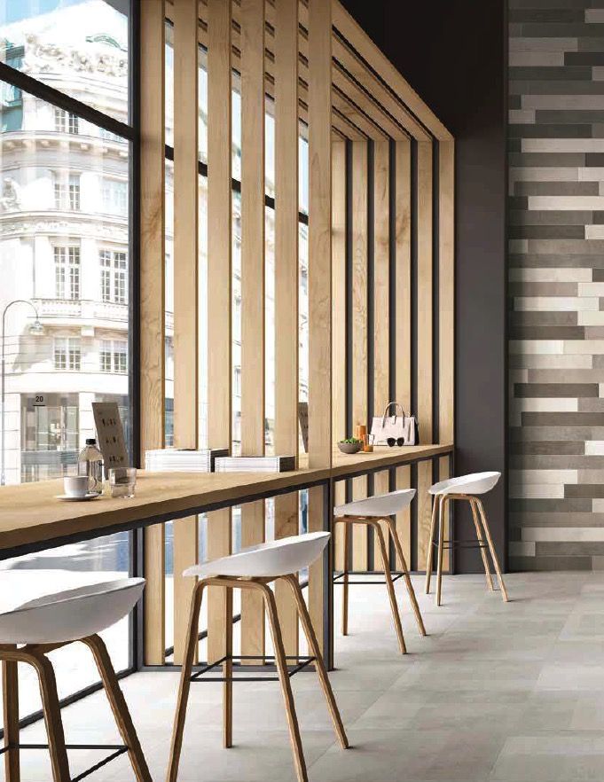 an empty restaurant with wooden tables and stools in front of large windows that have vertical blinds on them