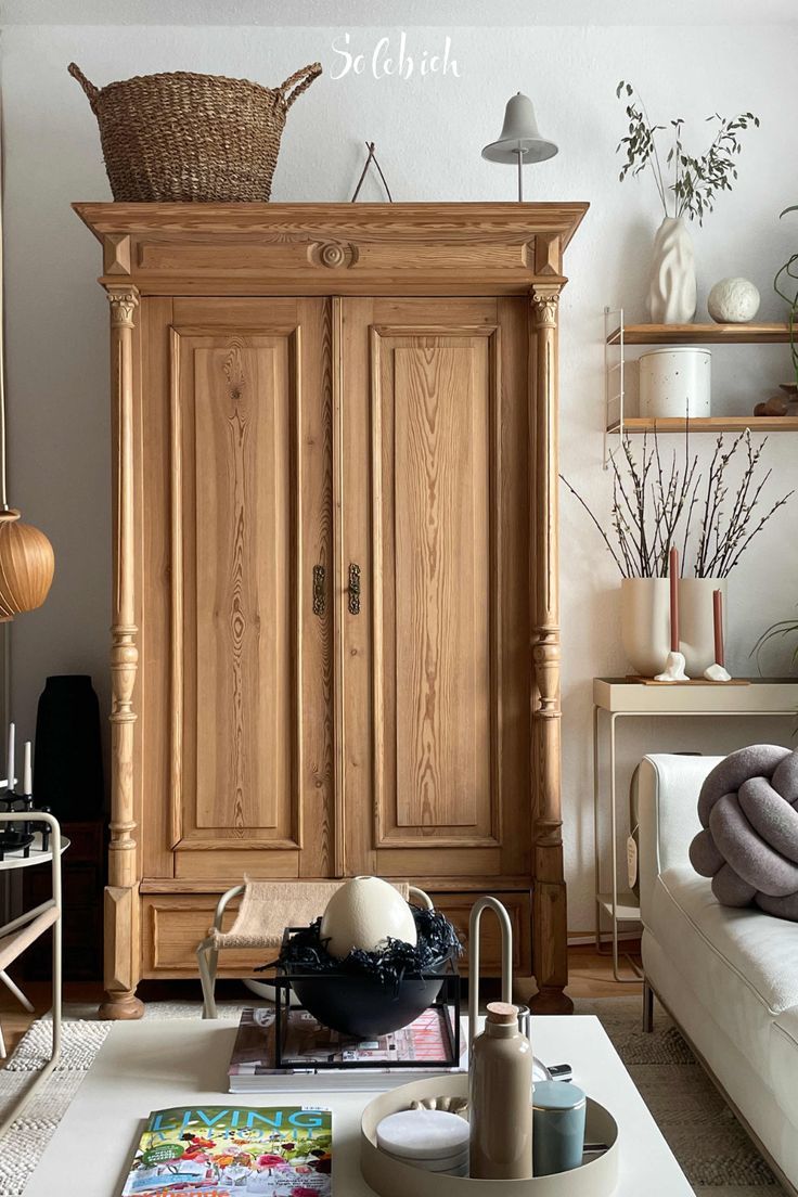 a living room filled with furniture and lots of woodwork on the walls in front of a large wooden armoire