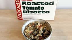 a bowl of food sitting on top of a table next to a box of tomatoes