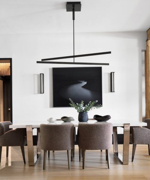 a dining room table with chairs and a painting on the wall