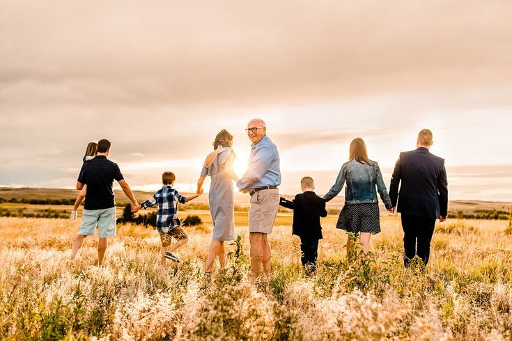 a group of people standing in a field holding hands