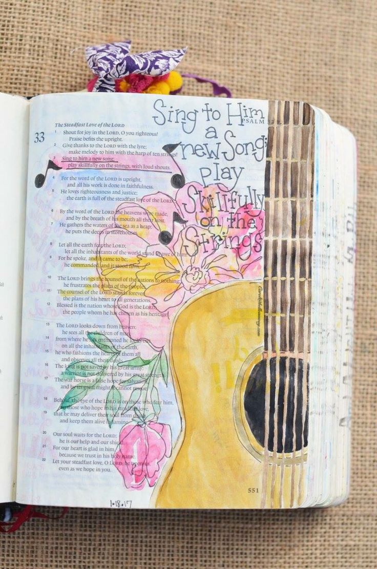 an open bible with a guitar and flowers on the page, which reads sing to him a new soft play