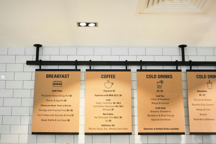 three menus hanging on the wall in a restaurant