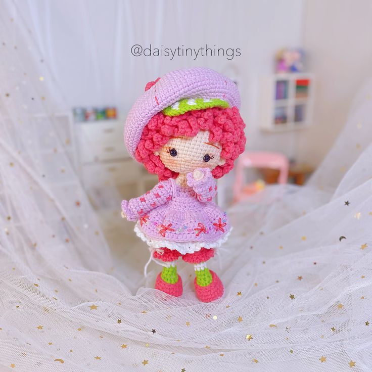 a small doll is wearing a pink hat and dress with green boots on her feet