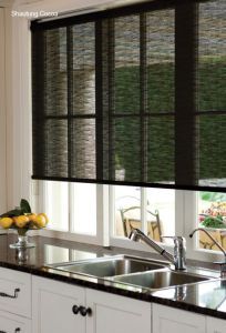 a kitchen with black roman shades on the windows and sink area in front of it