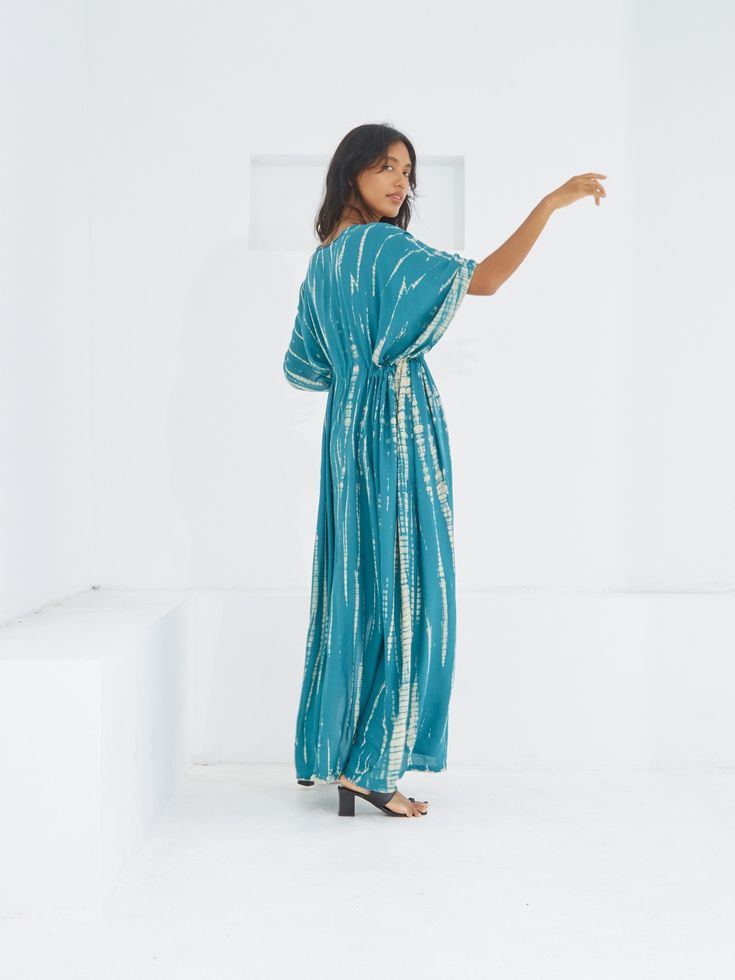 Switch to vacay mode anytime with the Goddess - Tie Dye Kaftan Maxi Dress. This undeniably sexy, breezy maxi dress will have you dreaming of the wind in your hair, the sound of the ocean waves, and the sand under your feet. Experience blissful comfort and breathability whether you’re at home or on vacay with the gorgeous flowy long dress and laid-back loose fit. Crafted in 100% soft, lightweight rayon, this dress features flawless tie-dye patterns and is perfect for tropical beachside vacations, Turquoise Maxi Dress For Beach Cover-up, Breezy V-neck Maxi Dress For Poolside, Flowy Breezy Rayon Maxi Dress, Turquoise V-neck Maxi Dress For Vacation, Flowy Short Sleeve Maxi Dress In Breezy Style, Flowy Breezy Maxi Dress With Short Sleeves, Flowy Breezy Short Sleeve Maxi Dress, Breezy Flowy Maxi Dress With Short Sleeves, Green Breezy Maxi Dress