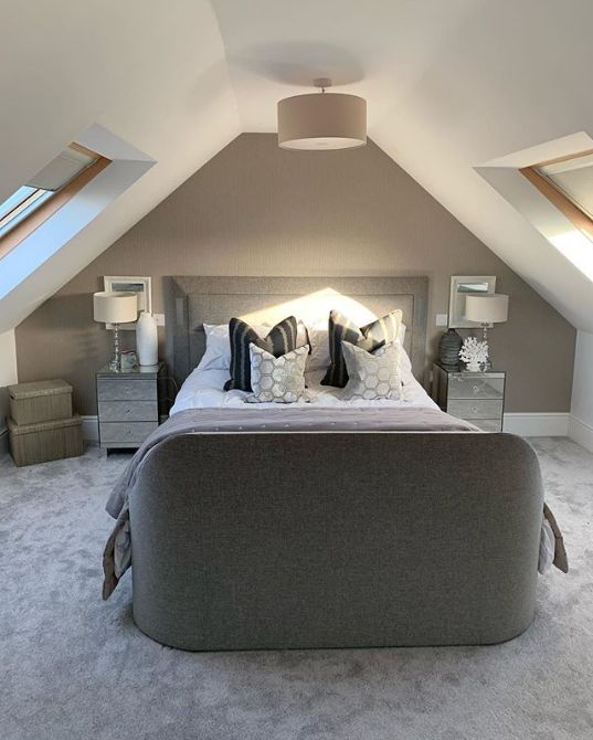 a large bed sitting in the middle of a bedroom next to two lamps on either side of it