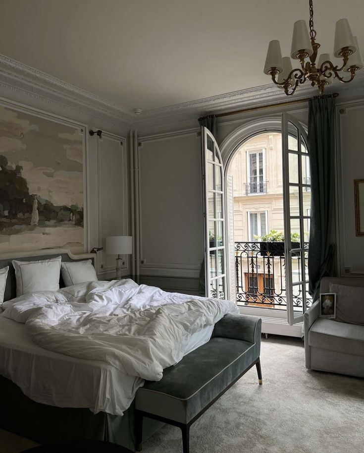 a bedroom with a large bed and french doors leading to an outside patio area that overlooks the city