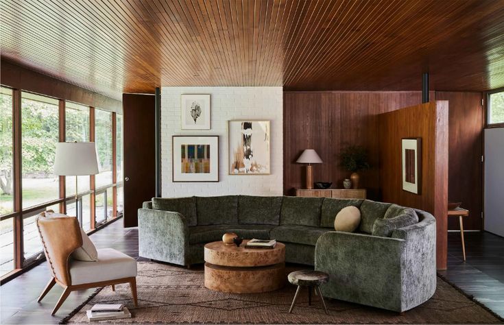 a living room filled with furniture and lots of wood paneled wallpaper on the walls