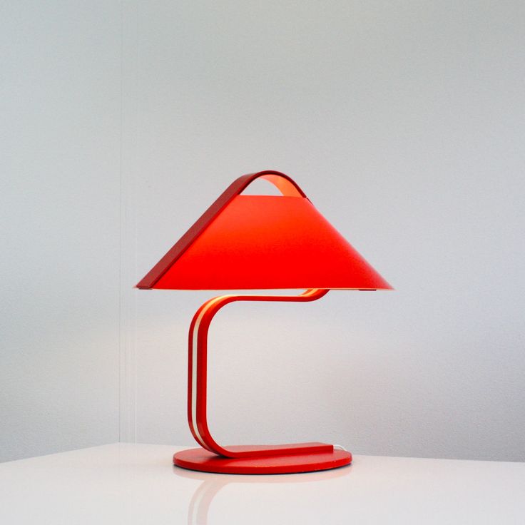 a red lamp sitting on top of a white table