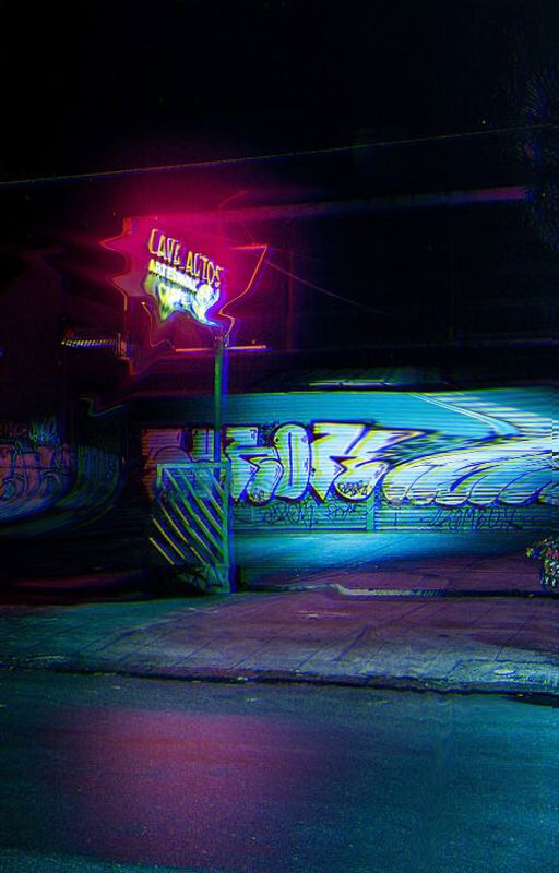 the skateboarders are riding their boards on the street at night with neon lights