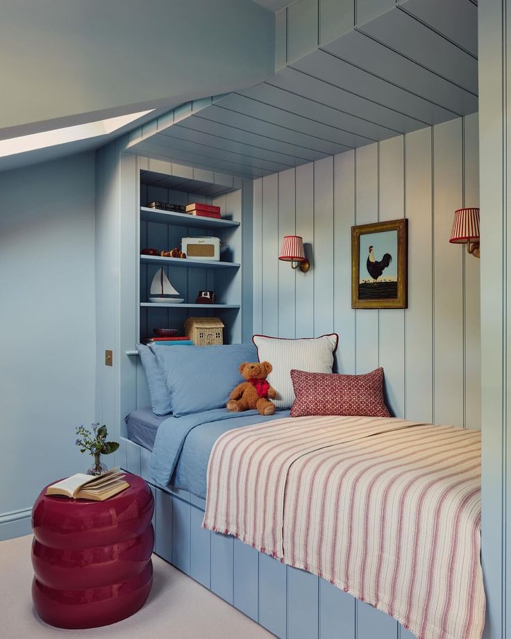 there is a small bed in the corner of this room with blue walls and striped bedspread