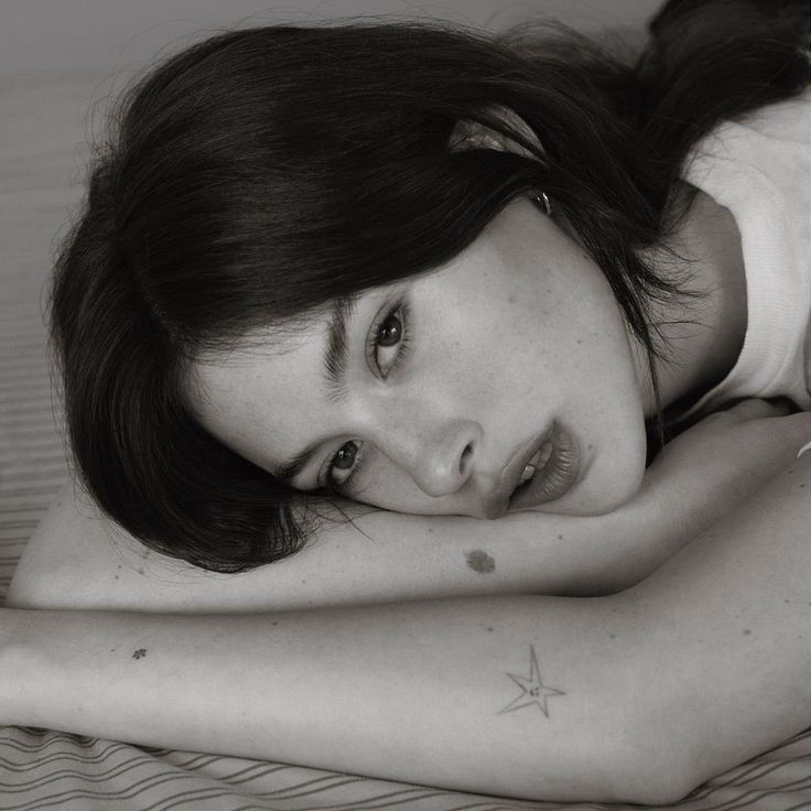 a woman laying on top of a bed next to a pillow