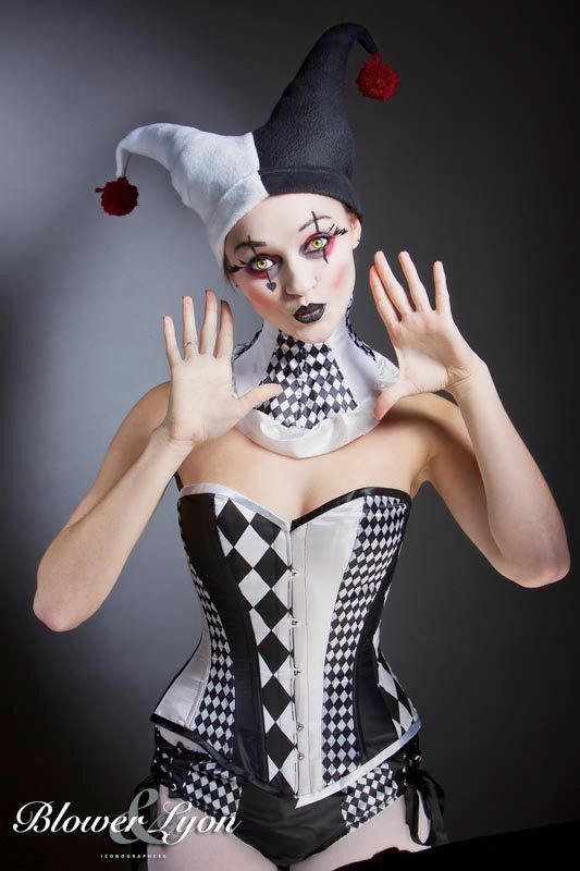 a woman dressed in black and white is posing for the camera with her hands up