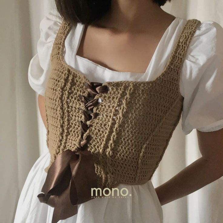 a close up of a mannequin wearing a crochet top with a bow