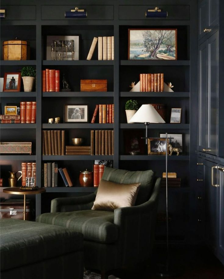 a living room filled with lots of bookshelves next to a couch and lamp