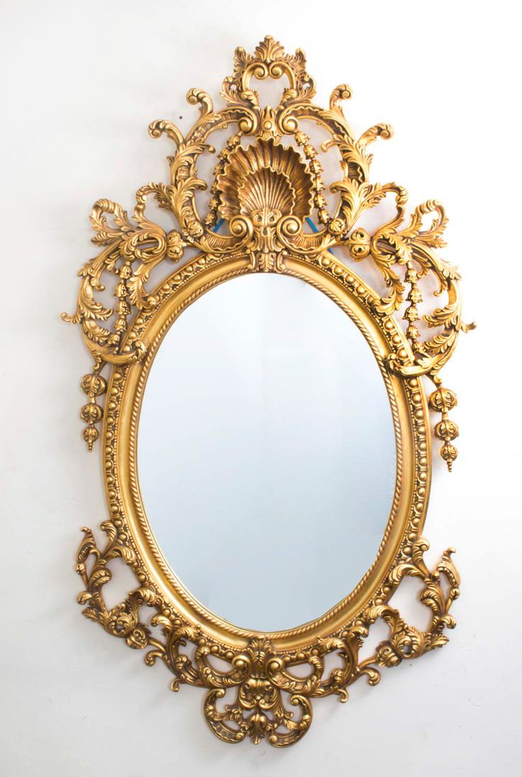 an ornate gold mirror hanging on the wall