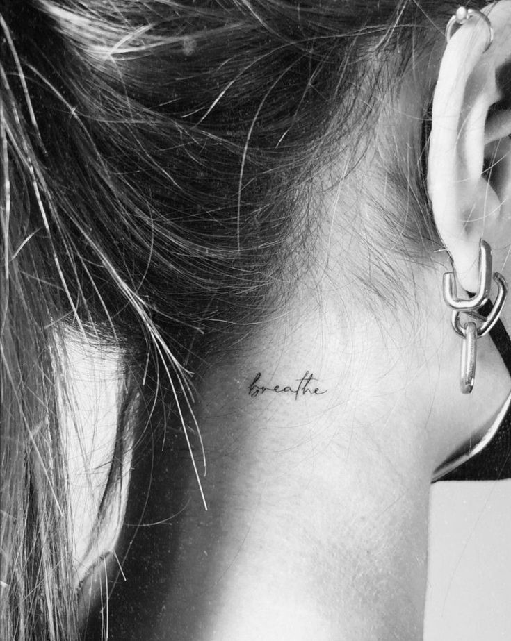 a woman with a small tattoo behind her ear