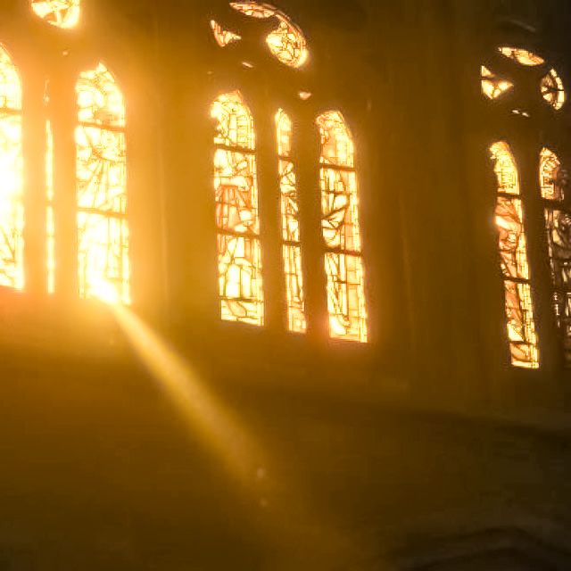 the sun is shining through two windows in an old building with multiple stained glass windows