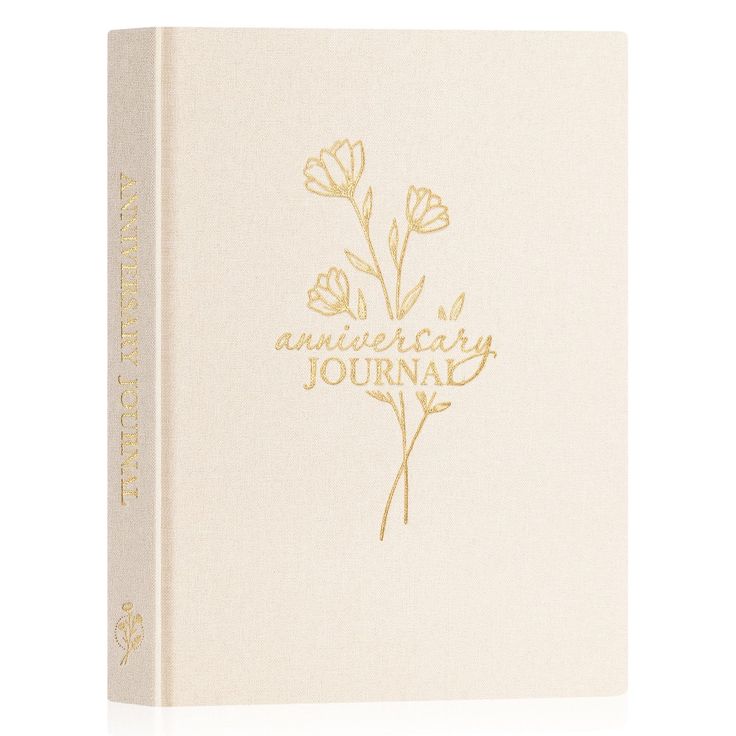 a white book with gold lettering and flowers