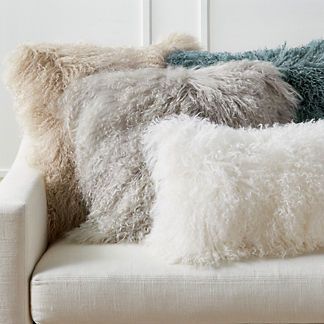 two pillows sitting on top of a white couch