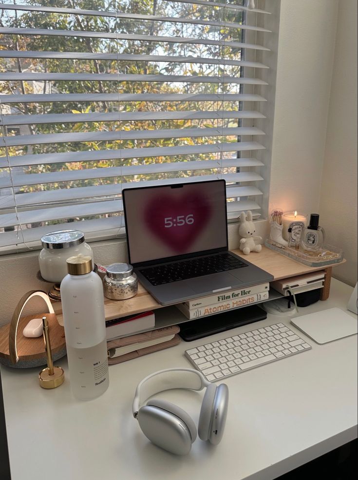 a laptop computer sitting on top of a desk next to headphones and other items