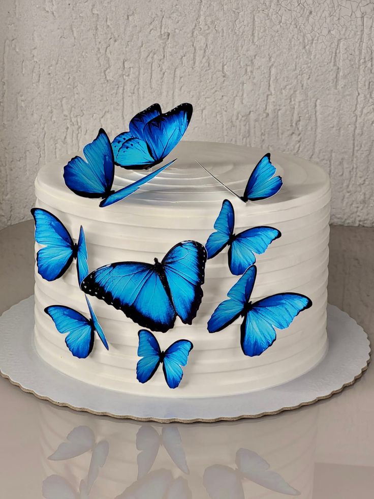 a white cake with blue butterflies on it