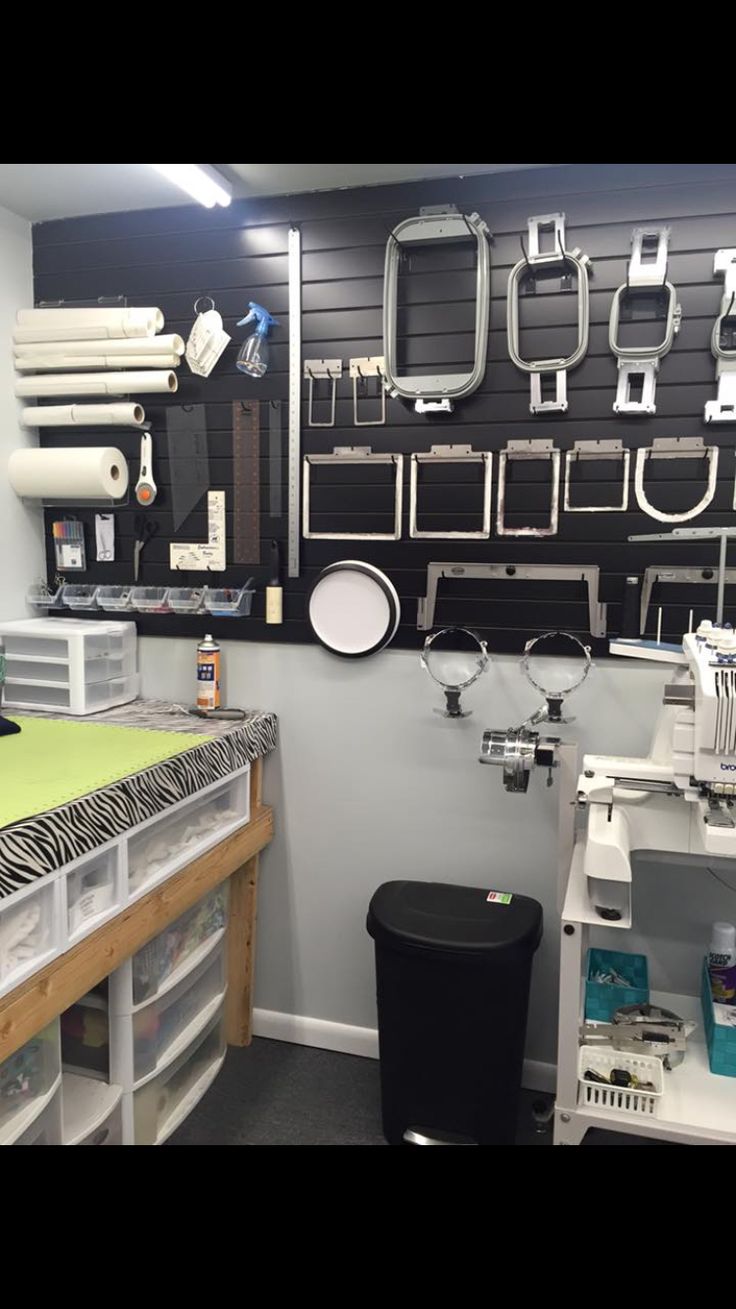 a sewing studio with lots of crafting supplies on the wall and shelves above it