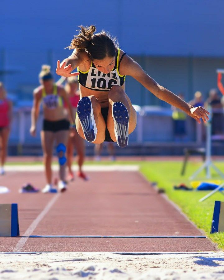 a woman is jumping in the air on a track