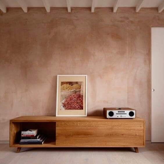 a wooden entertainment center with a radio on top of it next to a painting and bookshelf