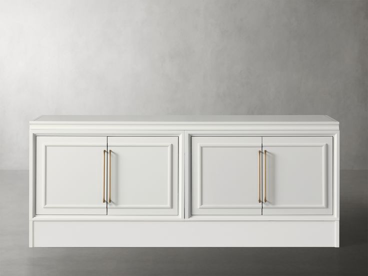 a white cabinet with three doors and two handles on each side, in front of a gray wall