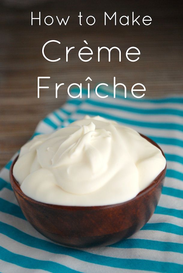 a wooden bowl filled with cream on top of a blue and white striped cloth